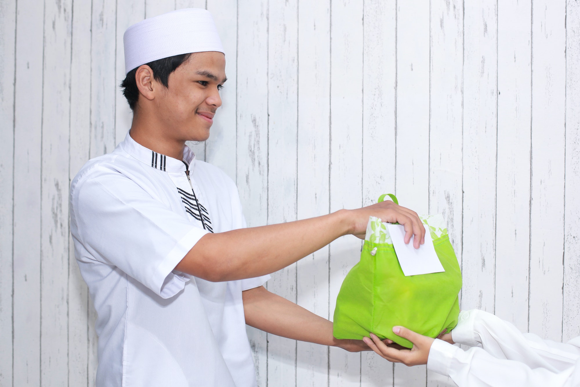 Muslim man giving gifts for an alms